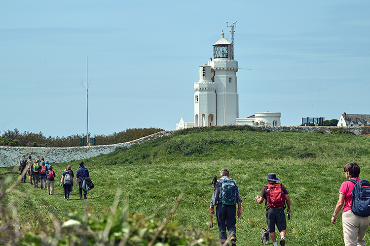 Walkers walking towards St Catherine's Lighthouse at St Catherine's Point, Isle of Wight